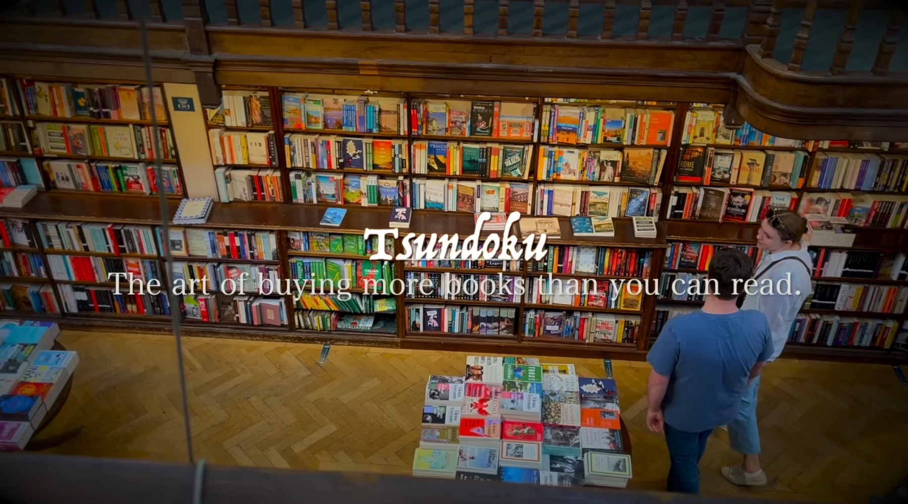A person in a bookstore is surrounded by shelves filled with books, along with the word Tsundoku and its definition overlaid on the image.
